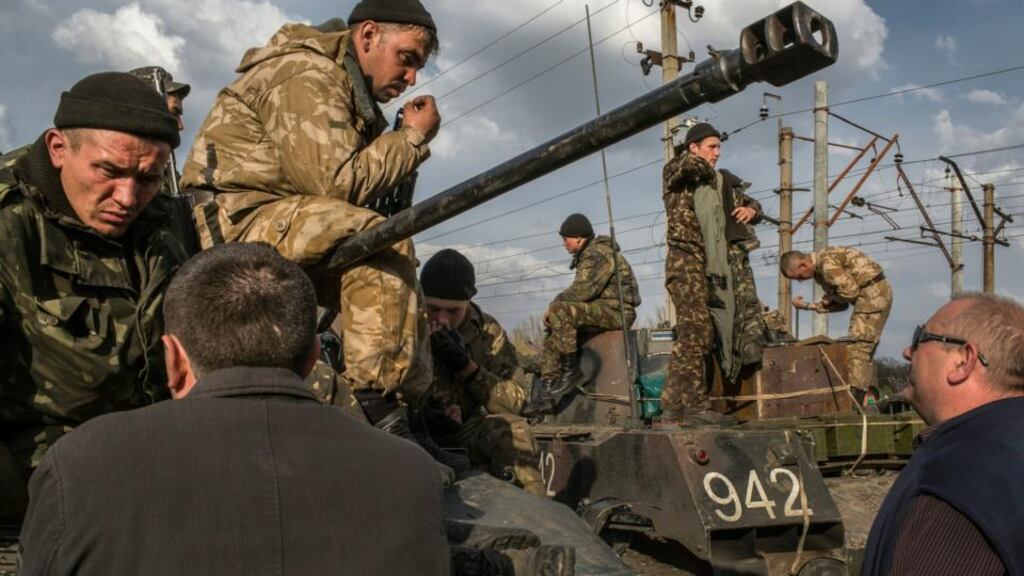 Villagers talk with Ukrainian soldiers as they gather at a railway to stop Ukrainian tanks moving towards the airport in Kramatorsk, Ukraine. Photograph: Mauricio Lima/The New York Times)