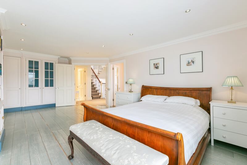 The main bedroom has double doors, wide-board timber flooring and built-in wraparound wardrobes