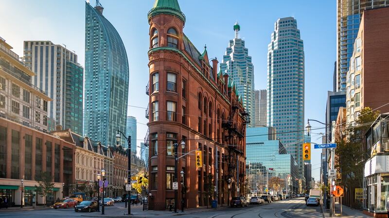 An old building in downtown Toronto with CN Tower on background