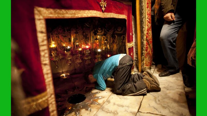 A Christian boy prays at the Grotto in the Church of the Nativity in Bethlehem, West Bank. The gold star embedded in the floor marks the spot where Jesus is believed to have been born. Photograph: Uriel Sinai/Getty Images
