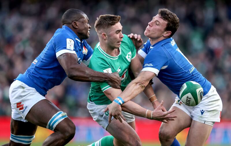 Jack Crowley offloads despite the attentions of Italy's Alessandro Izekor and Paolo Garbisi. Photograph: Dan Sheridan/Inpho