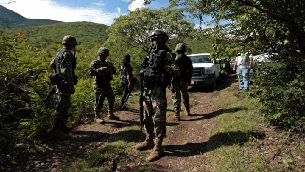 Soldiers guard an area where a mass grave was found in Colonia las Parotas on the outskirts of Iguala, in Guerrero State. Photograph: Jorge Dan Lopez/Reuters.