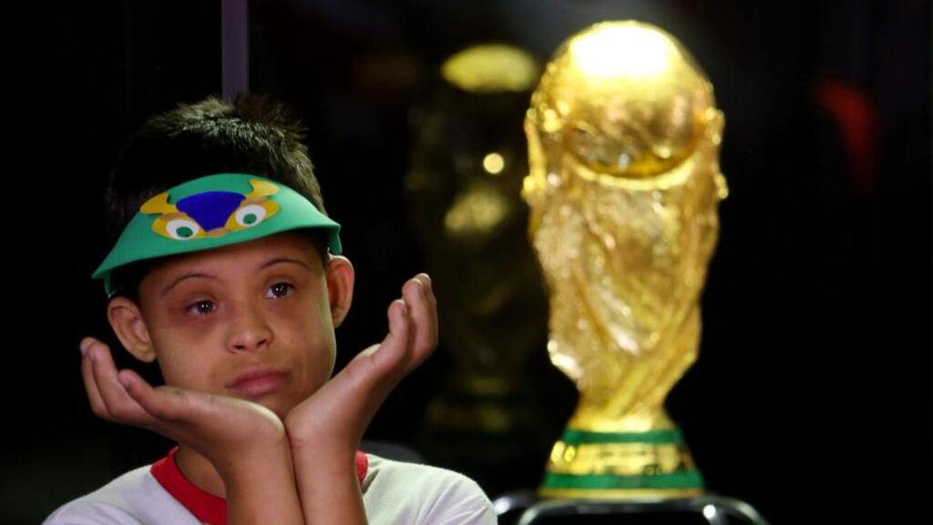 A Brazilian boy looks at the FIFA World Cup trophy on display at an exhibition in Brasilia, Brazil. Photograph: Fernando Bizerra/EPA