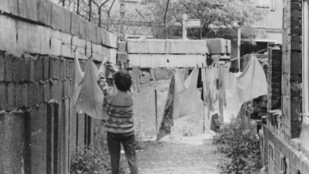 A woman hangs out washing in her back yard on a line attached to a section of the Berlin Wall in August 1963. Photograph: Keystone/Hulton Archive/Getty Images
