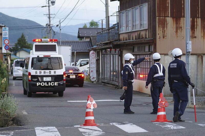 Police officers stand guard on a street leading to a building where a man was holed up in Nakano, central Japan. Photograph: Kyodo News/AP