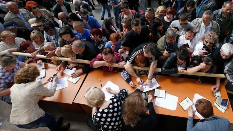 People stand in a line to receive ballots from members of a local election commission during the referendum on the status of Donetsk region in the eastern Ukrainian city of Mariupol today. Photograph: Reuters