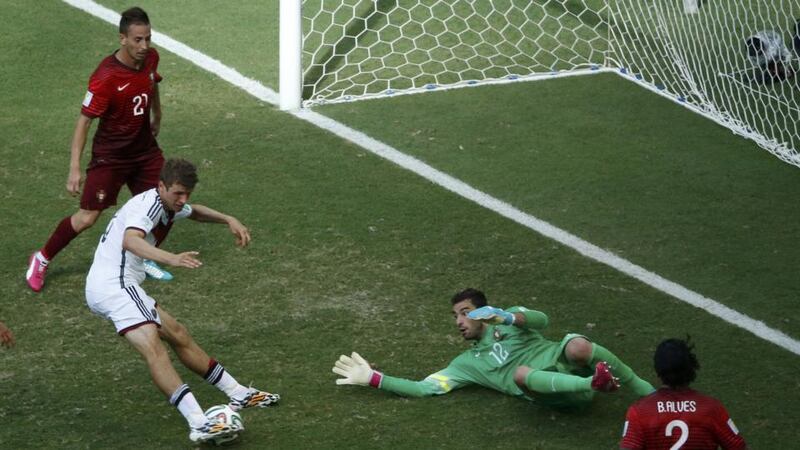 Thomas Müller slides in his third goal with Portugal’s Rui Patricio stranded in Germany’s opening World Cup Group G victory in Salvador. Photograph: Fabrizio Bensch.