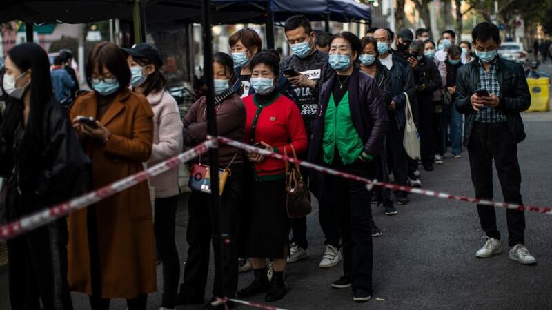 Residents in Wuhan wear masks while lining up to receive a Covid-19 vaccine in the Chinese city on Friday. Photograph: Getty Images
