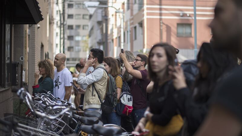Tourists watch on through the open windows of the Arashio sumo stable. Photograph: Mirco Lazzari gp/Getty Images