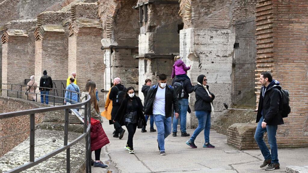 Tourists wearing respiratory masks at the Coliseum in Rome. Photograph: Getty Images