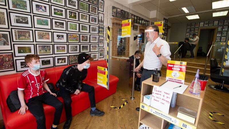 Gerry McKeever calls Paul Hannigan for a haircut as his brother Luke  waits his turn in Gerry’s Barbers. Photograph: Joe Dunne