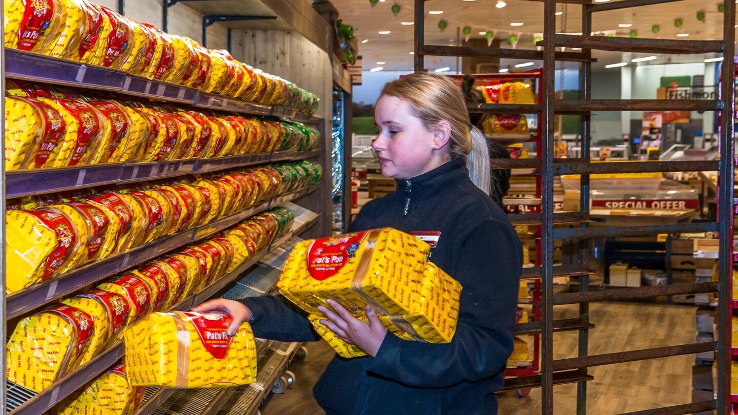 Ali Duggan re-stocks the empty shelves with fresh bread at Barry Collins SuperValu in Carrigaline, Co Cork after Storm Emma. Photograph:  David Creedon / Anzenberger
