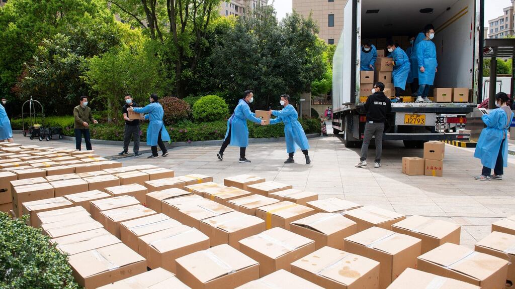 Volunteers deliver boxes of food to residents in a compound during a Covid-19 lockdown in Pudong district in Shanghai. Photograph: Liu Jin/AFP