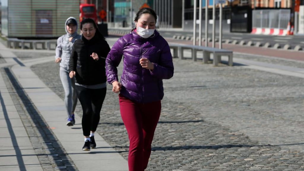 People follow social distancing guidelines as they go for a run in Dublin’s city centre. Photograph: Brian Lawless/PA Wire
