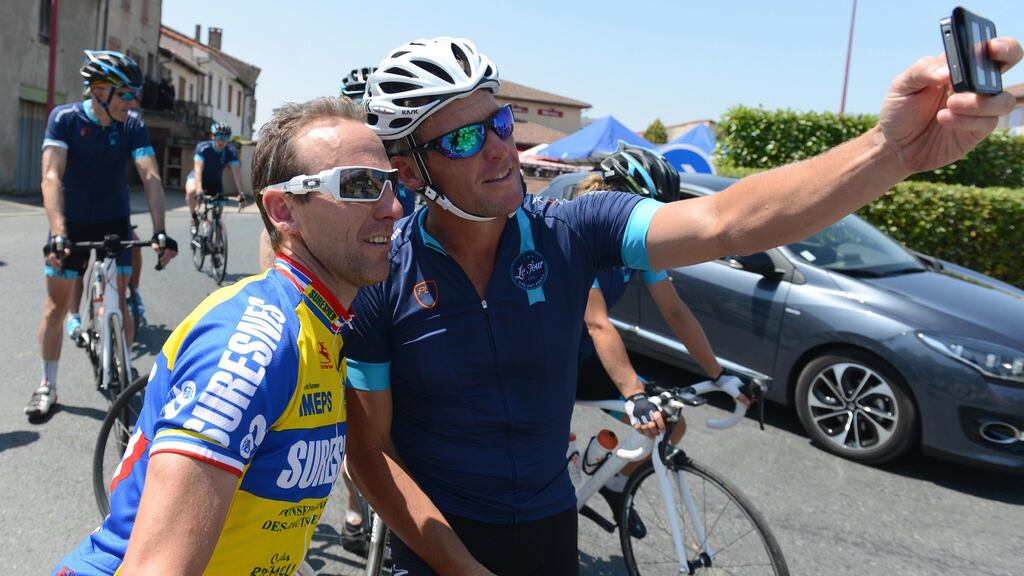 Lance Armstrong poses for a selfie as he rides with Cure Leukaemia charity riders during stage thirteen of the One Day Ahead - Le Tour 2015 on July 16, 2015 in Rodez, France. Photo: Sam Bagnall/Getty Images