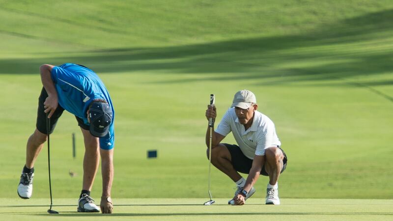 Former US President Barack Obama prepares to putt on the 18th green as friend Greg Orme retrieves his ball at the Kapolei Golf Club. Photograph: Getty Images
