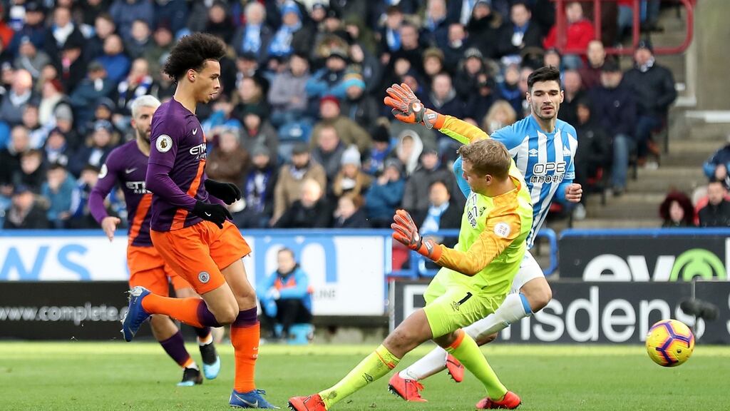 Manchester City’s Leroy Sané scores his side’s third goal during the Premier League match against Huddersfield at the John Smith’s Stadium. Photograph: Martin Rickett/PA Wire