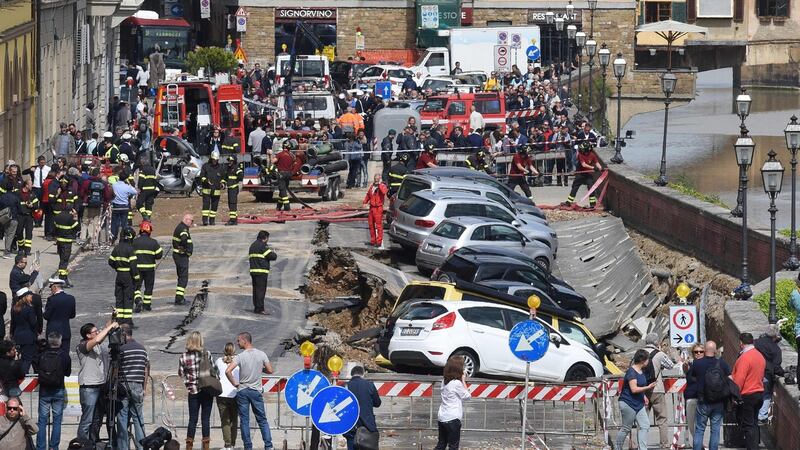 Firemen work along the Arno river where the embankment running alongside the Arno river collapsed in central Florence. Photograph: Claudio Giovannini/AFP/Getty Images