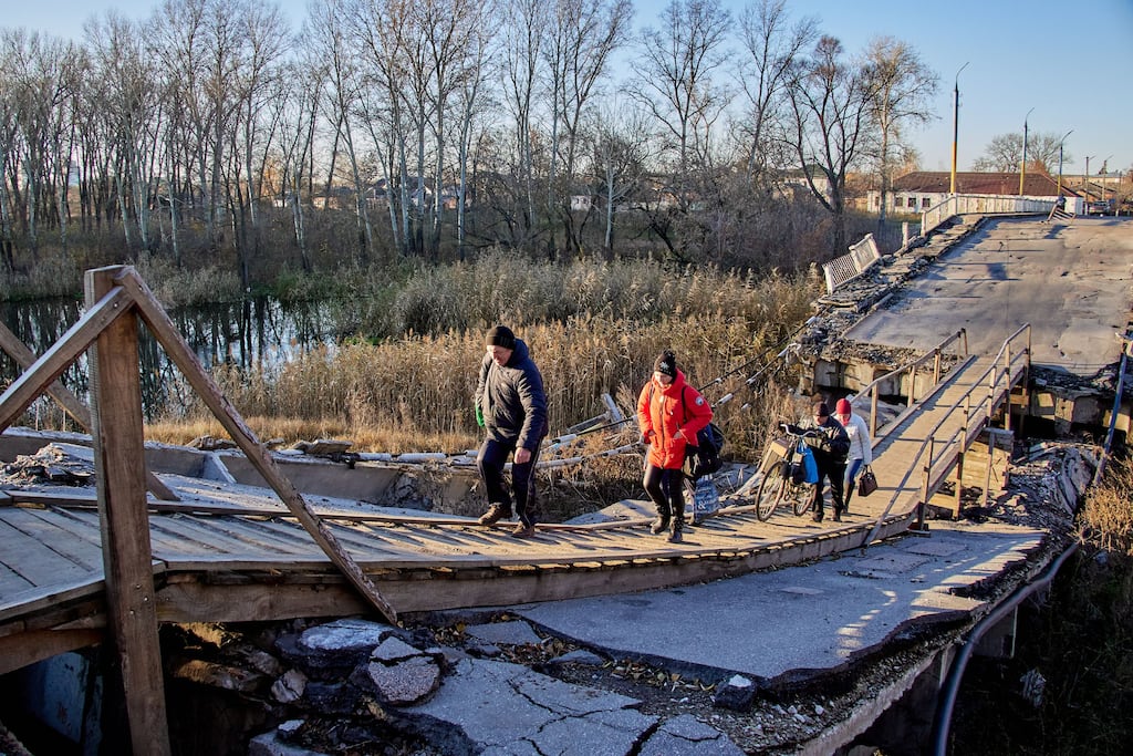 Ukrainians walk on a damaged bridge in the town of Vovchansk, in Kharkiv region. Photograph: Sergiy Kozlov/EPA