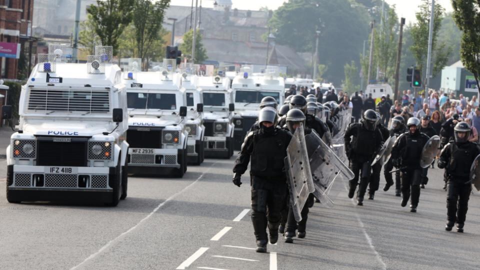 PSNI in riot gear move into position to escort the Orange Order feeder parade past the Ardoyne shops. Photograph: Paul Faith/PA Wire