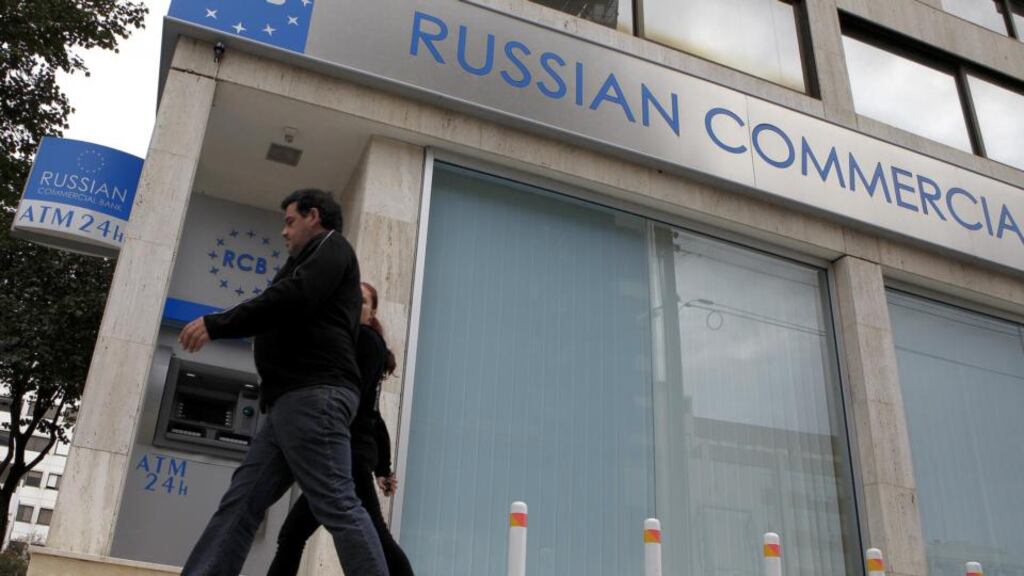 A couple pass outside the Russian commercial bank in Nicosia yesterday. A high proportion of deposits in Cypriot banks are believed to be held by Russians. Photograph: Petros Karadjias/AP
