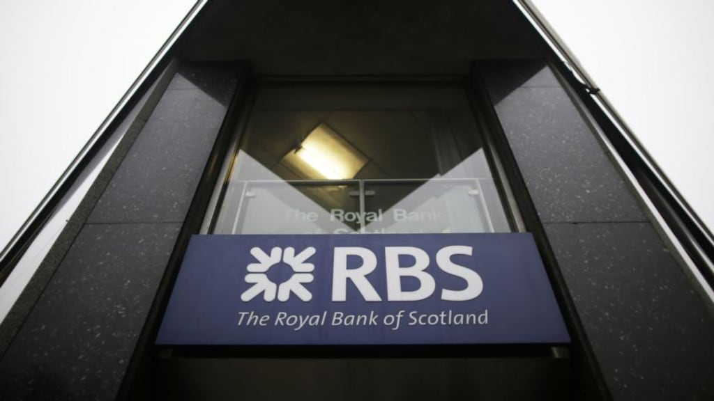A logo sits on a sign outside a branch of Royal Bank of Scotland Group in London. The banking group has suspended a third foreign-exchange trader amid an internal probe. Photo: Bloomberg
