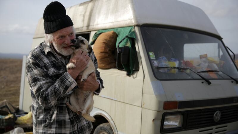 Lubbers hugs one of the stray dogs he and his partner were looking after. Photo: Stoyan Nenov/Reuters