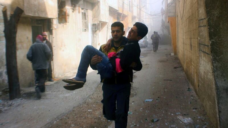 A man is carried to safety in the aftermath of an air strike in Ghouta, a suburb of Damascus, Syria. Photograph: Syrian Civil Defense White Helmets via AP