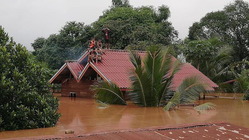 Residents on rooftops surrounded by floodwaters in Attapeu province after a dam collapsed on Monday. Photograph: AFP/Getty Images