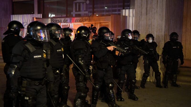 Catalan regional police officers of the  Mossos d’Esquadra  stand guard outside Barcelona’s stock market during clashes following a demonstration against the imprisonment of Spanish rapper Pablo Hasel  on Saturday. Photograph: Pau Barrena/AFP/Getty