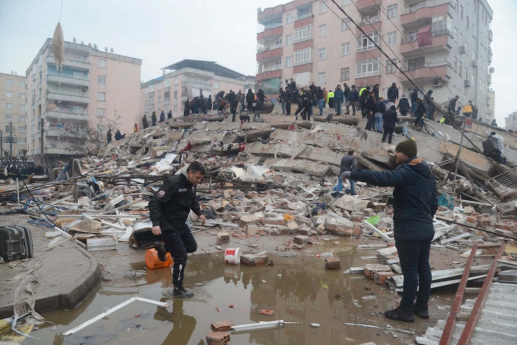 People search for survivors through the rubble in Diyarbakir, south-east Turkey on Monday, after a 7.8-magnitude earthquake struck. Photograph: Ilyas Akengin/AFP via Getty Images