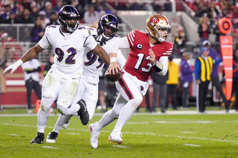 Brock Purdy of the 49ers is pursued by Justin Madubuike and Odafe Oweh of the Baltimore Ravens. Photograph: Loren Elliott/Getty Images