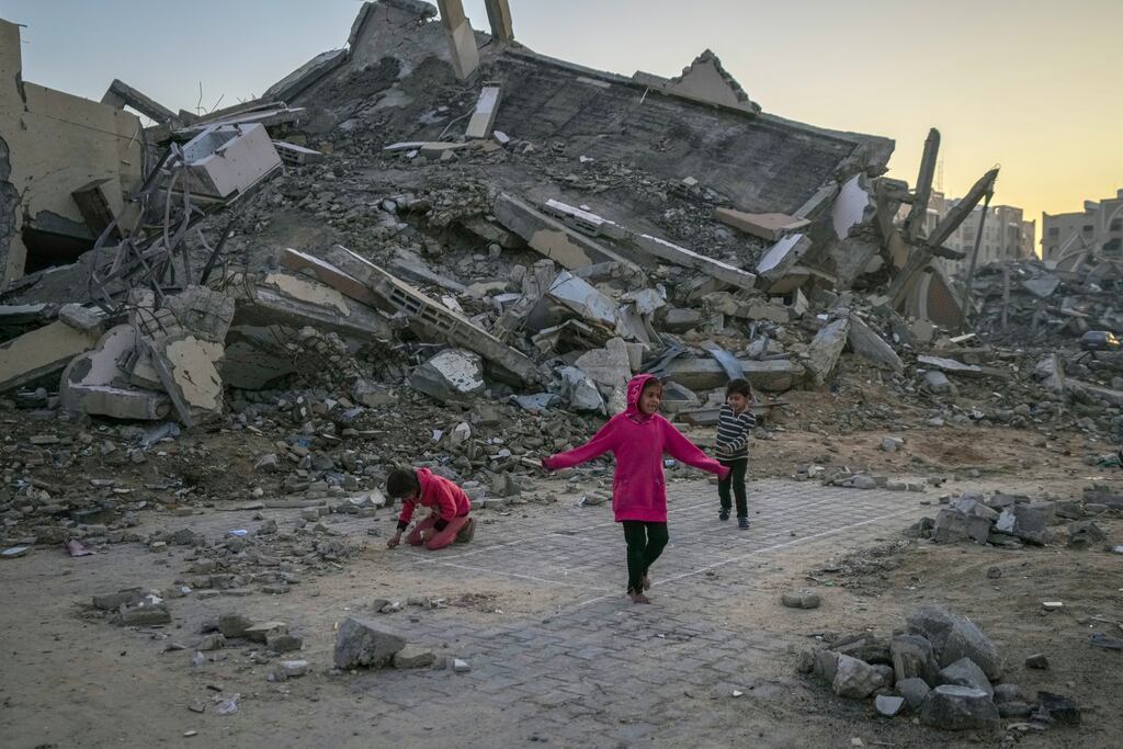 Palestinian children play next to a building destroyed by Israeli army strikes in the central Gaza Strip town of Khan Younis. Photograph: Abdel Kareem Hana/AP