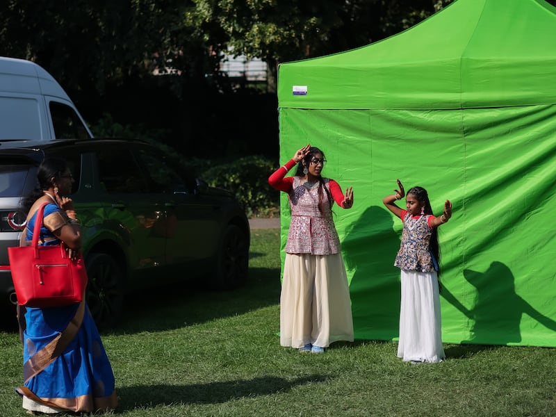 Sisters Srikruthi and Srimanya, with their mum, practise their dance routine in Merrion Square. Photograph: Dan Dennison/The Irish Times