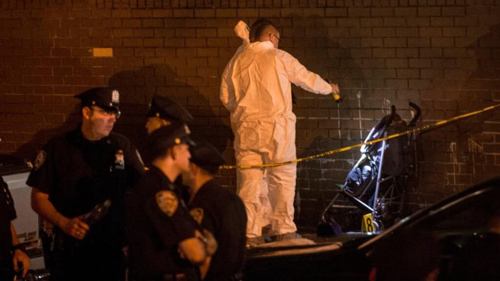 A crime scene unit analyses the pram Antiq Hennis (1) was in when he was shot as the family crossed Livonia Avenue in New York. Photograph: New York Times
