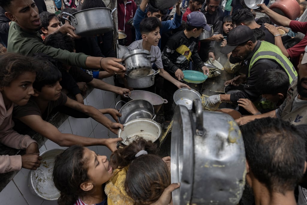 People reach out last month for food at a charity kitchen in Jabaliya in the Gaza Strip, where international agencies say people are now at critical risk of famine. Photograph: Saher Alghorra/The New York Times