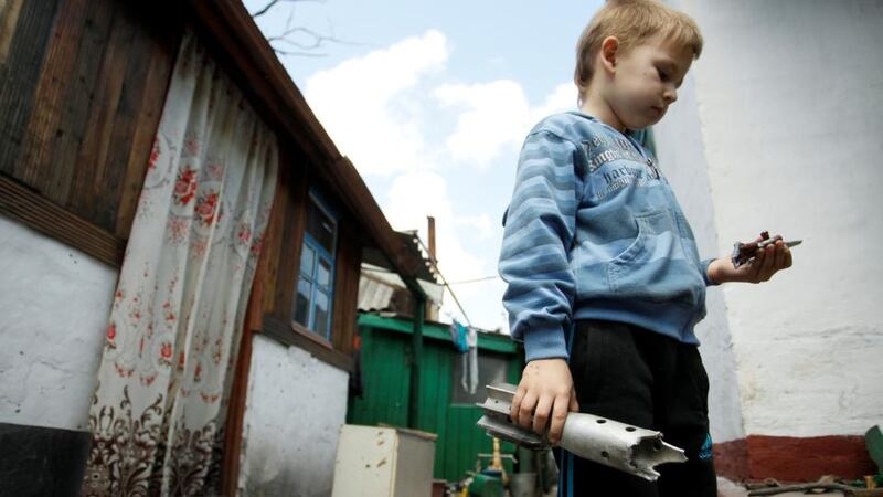 A boy holds the remains of a mortar shell which hit a residential building in a village outside Donetsk. Photograph: Reuters/Alexander Ermochenko