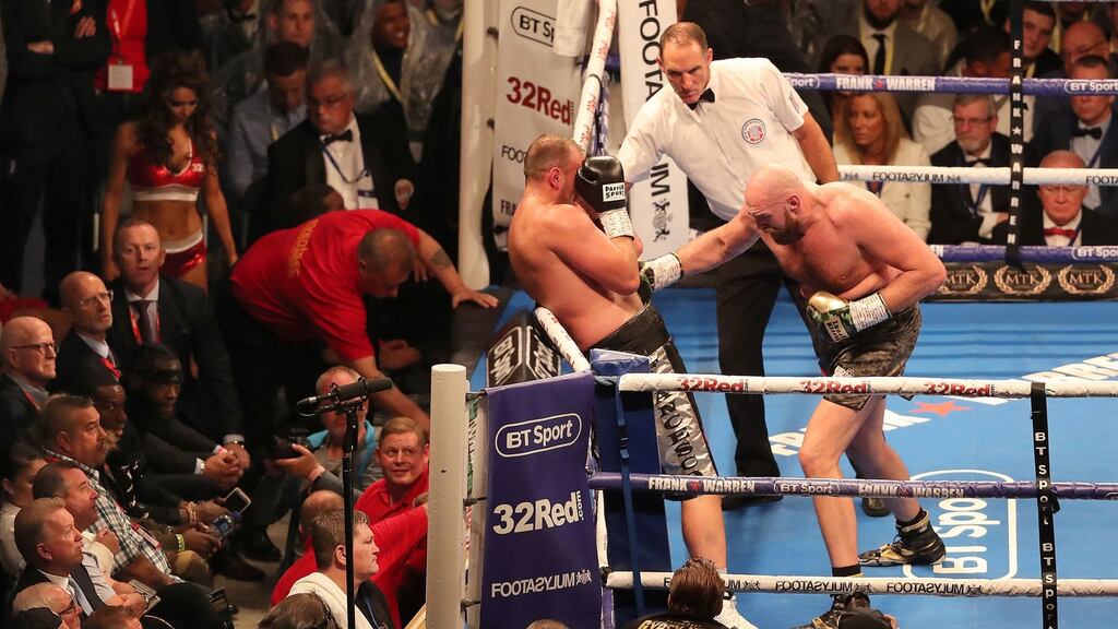 Tyson Fury (right) in action against Francesco Pianeta as Deontay Wilder (ringside, left) watches during the heavyweight fight at Windsor Park in Belfast. Photograph: Niall Carson/PA Wire