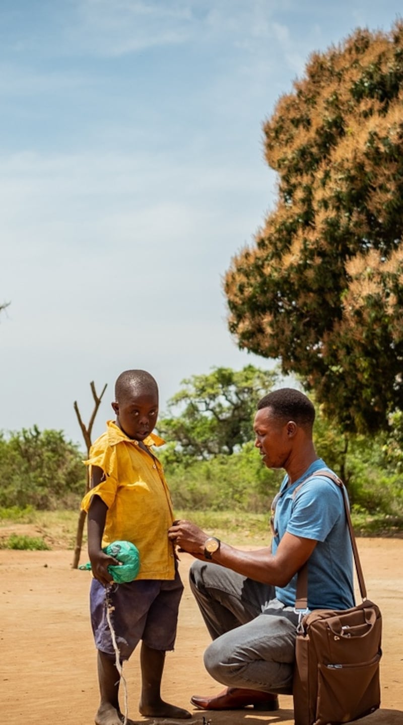 Pastor Fred Alimet buttons up Silus Odii’s shirt after releasing him from being tethered inside. Photograph: Christopher Hopkins