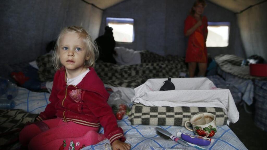A Ukrainian girl sits on a bed inside a tent at a refugee camp about 10 km from the Izvarino Russia-Ukraine border checkpoint in Rostov region, Russia. Photograph: Yuri Kochetkov/EPA