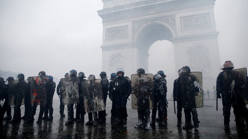 French riot police stand guard at the Arc de Triomphe during clashes with protesters wearing yellow vests at the Place de l’Etoile in Paris, France. Photograph: Stephane Mahe/Reuters