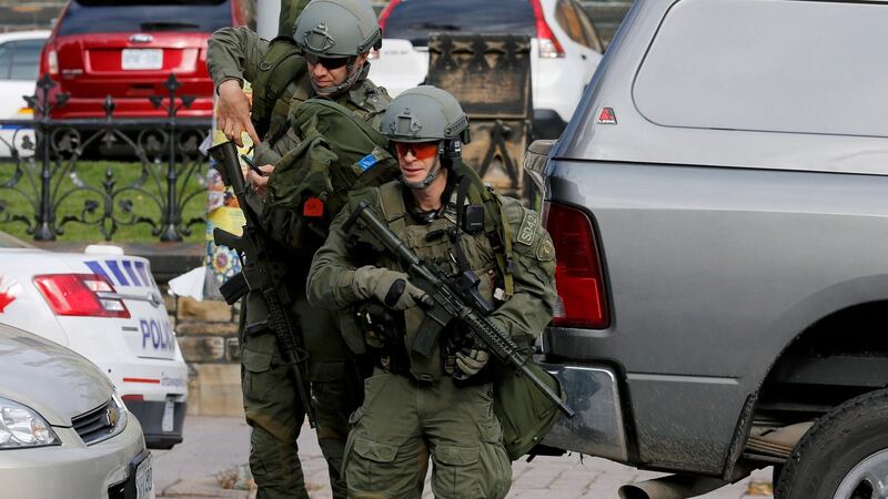 Armed RCMP officers approach Parliament Hill. Photograph: Chris Wattie/Reuters