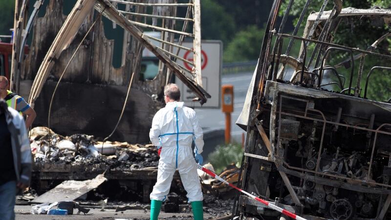 A forensic expert works at the scene where a tour bus burst into flames following a collision with a trailer truck on the highway A9 near Münchberg, southern Germany. Photograph: Nicolas Armer AFP/Getty Images