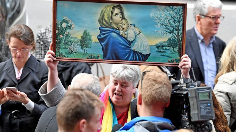 A supporter holds a religious painting outside the Melbourne court on Wednesday. Photograph: Joe Castro/EPA