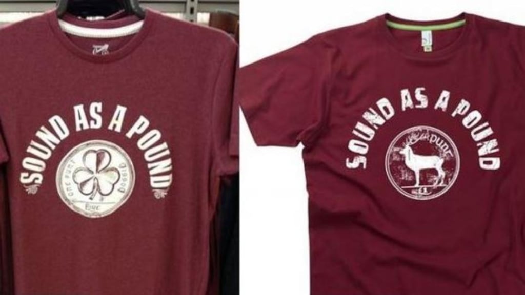 The Hairy Baby version of the T-shirt at the centre of the row (above right), which is purple, features an old punt coin image encircled by the phrase “Sound as a pound” in white lettering.  The Dunnes Stores T-shirt (above left) is also purple and features a coin circled by the phrase “Sound as a pound” in white lettering.
