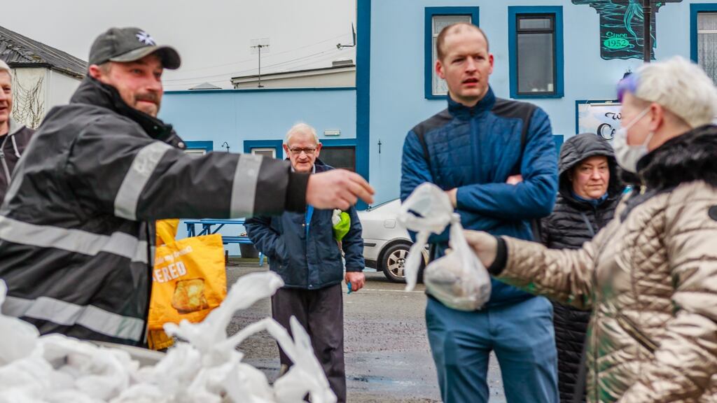 Trawler skipper Damien Turner hands out bags of fresh fish at Castletownbere with  Chris Downey, owner-manager of SuperValu. Photograph: Anne Marie Cronin