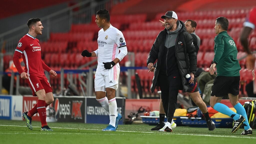 Casemiro of Real Madrid clashes with Andy Robertson of Liverpool as Jürgen Klopp reacts during the Champions League clash at Anfield. Photo: Michael Regan/Getty Images