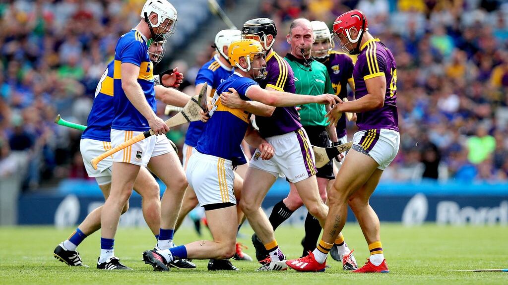 Referee Seán Cleere looks on as Wexford and Tipperary players clash during  the All-Ireland hurling semi-final at Croke Park. Photograph: Ryan Byrne/Inpho