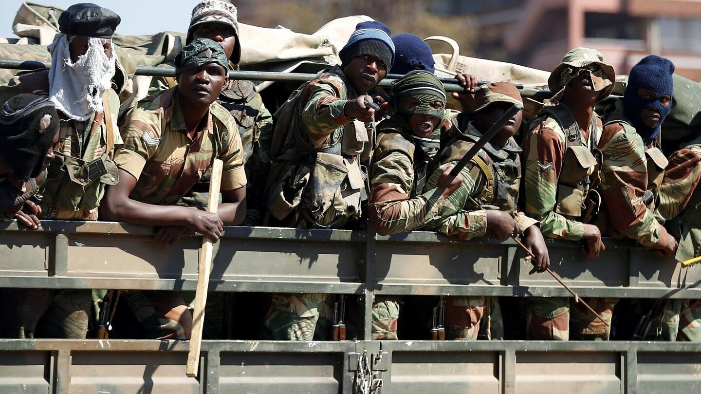 Members of the military gesture patrol the streets of Harare on Thursday. Photograph: Siphiwe Sibeko/Reuters