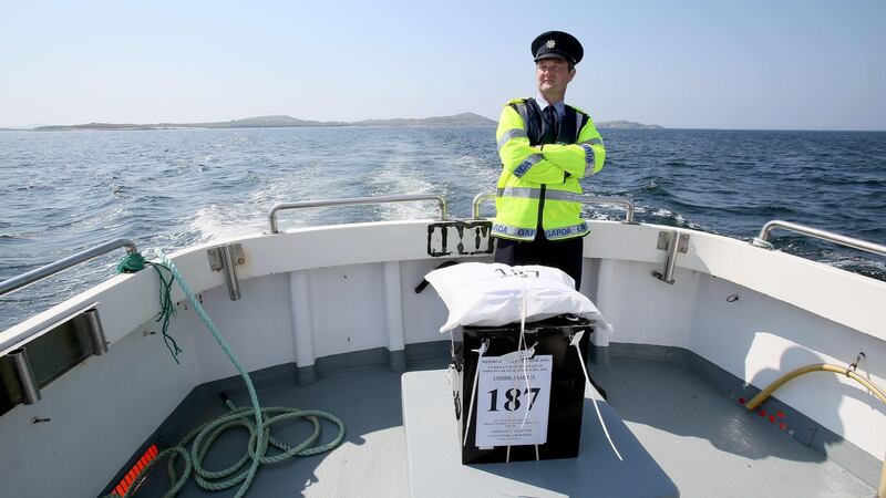 Garda officer Pat McElroy stands with the sealed ballot box as he travels back to the mainland from Gola Island, off the Donegal coast, one of 12 island communities voting on Thursday in the referendum on whether to repeal the Eighth Amendment. Photograph: Paul Faith/AFP/Getty Images